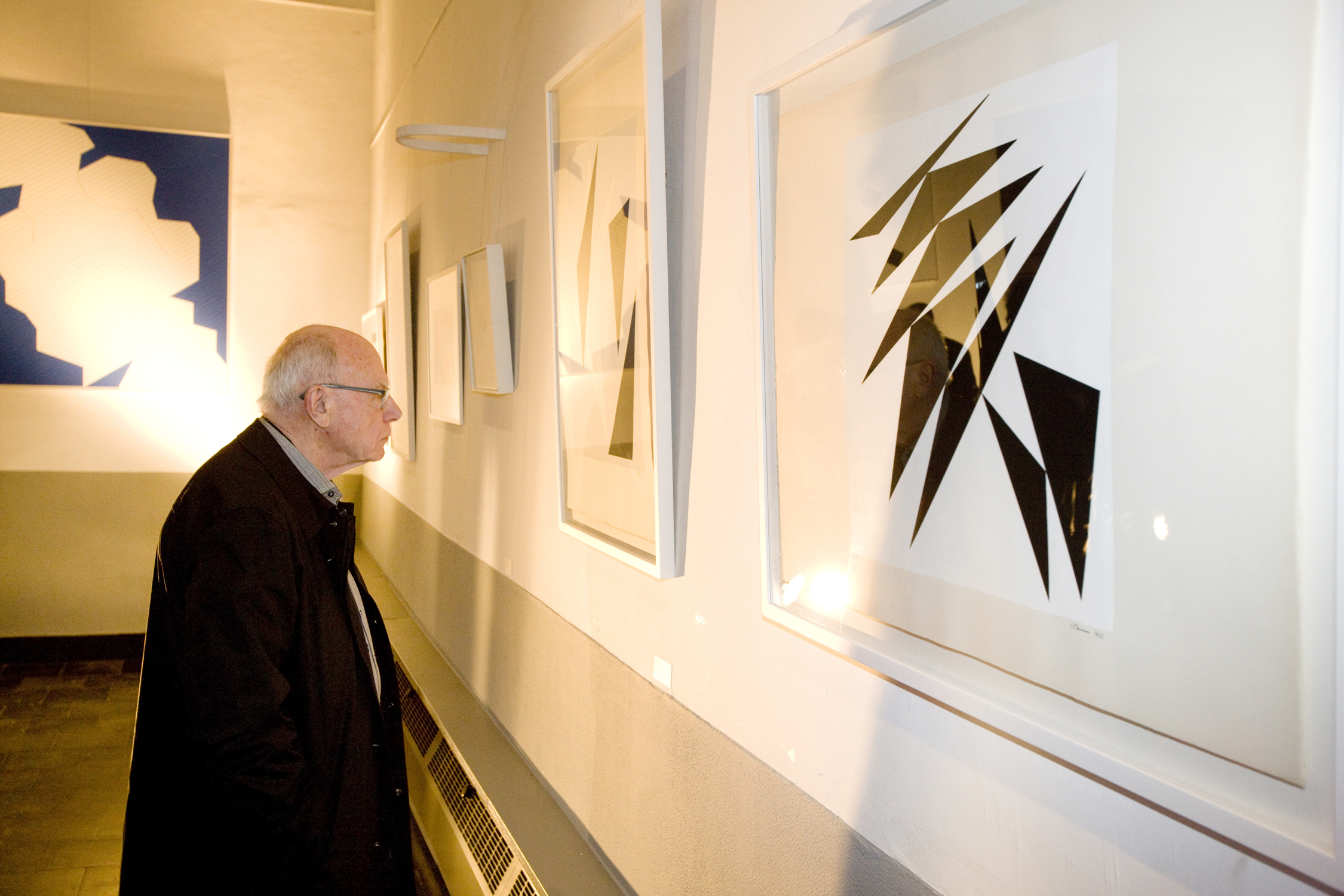 A visitor of the exhibition 'elementaire vormen' in Eeklo looks to the work of Geneviève Claisse. (photo: Grégoire De Poorter, 2013)